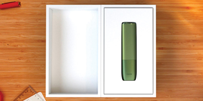 يدان تفتحان علبة جهاز IQOS.